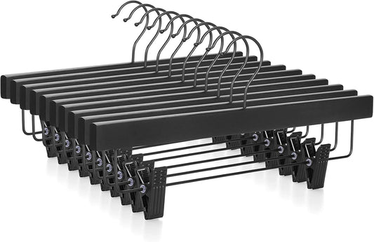 Set of black wooden pants hangers with clips and curved hooks, side view