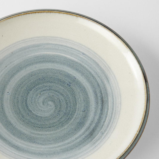 Ceramic plate top view with blue-gray concentric swirl glaze and cream rim