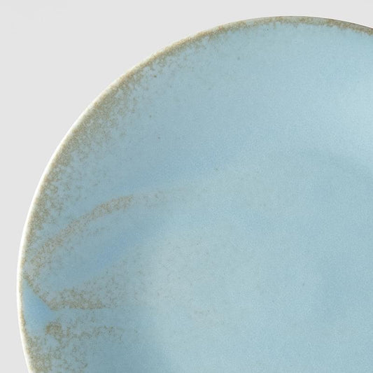 Soda-blue glazed tapas plate, close-up of speckled surface and rim
