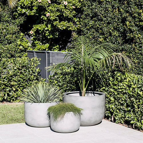 The Chop planter set in light concrete grey, three round pots with plants
