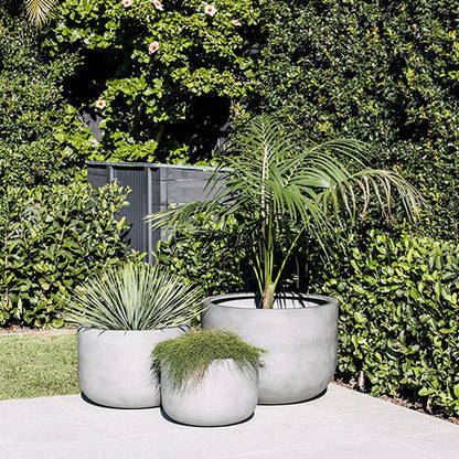 The Chop planter set in light concrete grey, three round pots with plants