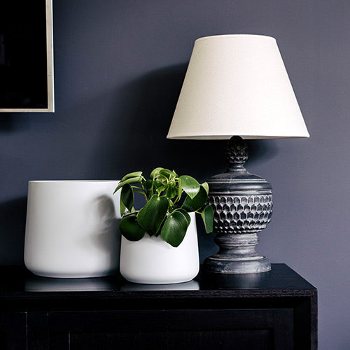 Cream planter pots set of three on dark table with leafy plant