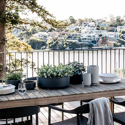 Tops Off planters with succulents in a dark grey pot on a wooden table