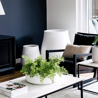 Tops Off planters with green seedlings in white pots on a small outdoor table
