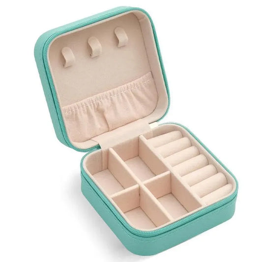 Travel jewelry organizer box in green with open compartments and ring slots