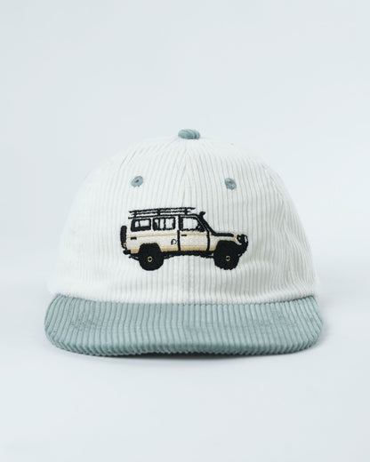White ribbed mini lid cap with teal patch brim and embroidered truck graphic