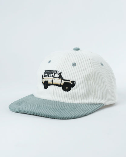 White ribbed cap with teal underbrim and embroidered van graphic on front