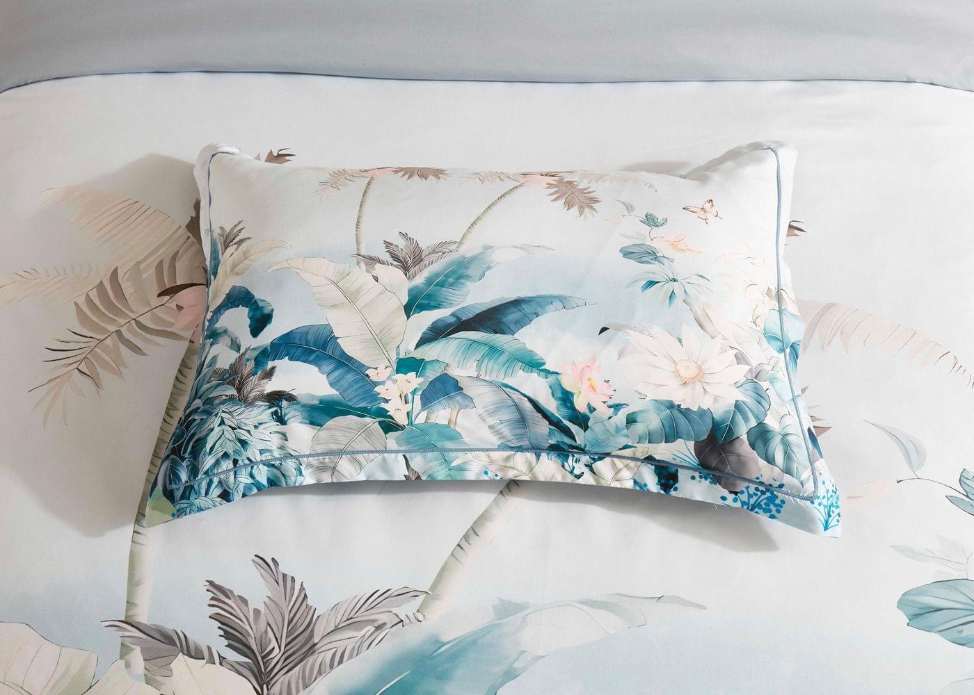 Blue and white tropical pillowcases with palm and floral print on quilt cover