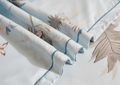 Tropical quilt cover fabric close-up with blue trim and palm leaf pattern
