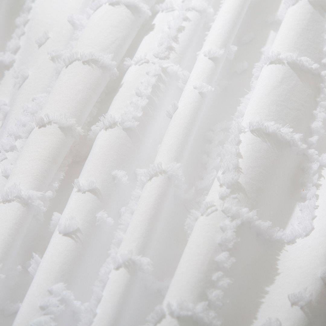 White quilt fabric with embroidered tufted diamonds and soft fringe trim