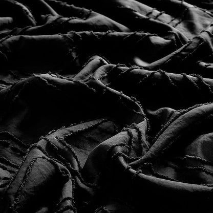Black jacquard duvet cover closeup with raised geometric quilting and stitched detailing