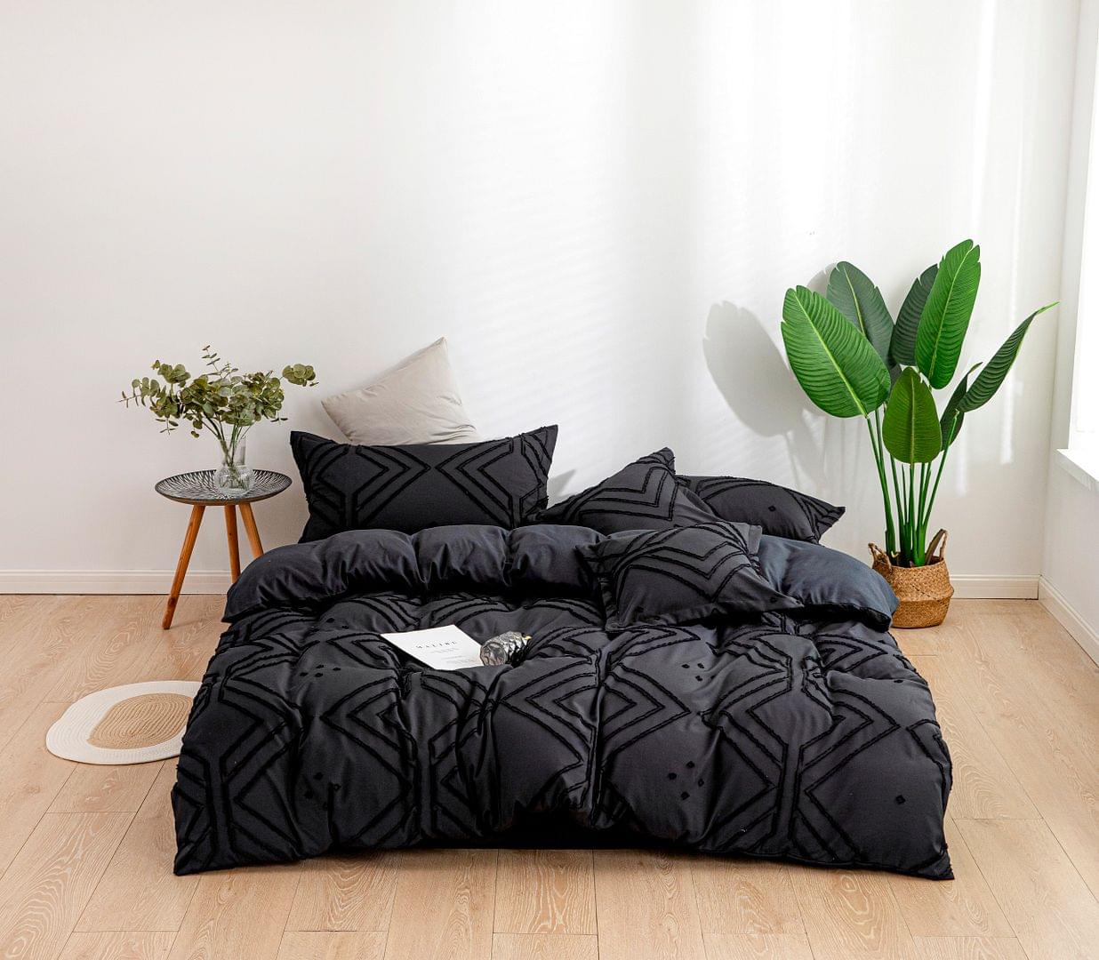Black jacquard duvet cover set with geometric quilting and two matching decorative pillows