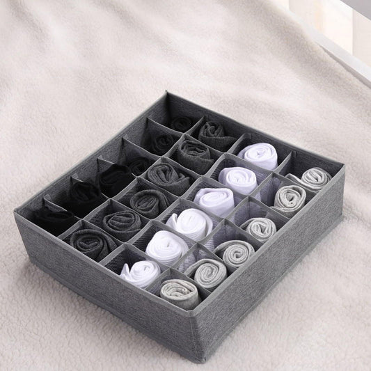 Gray fabric drawer organizer with compartments holding rolled socks and underwear
