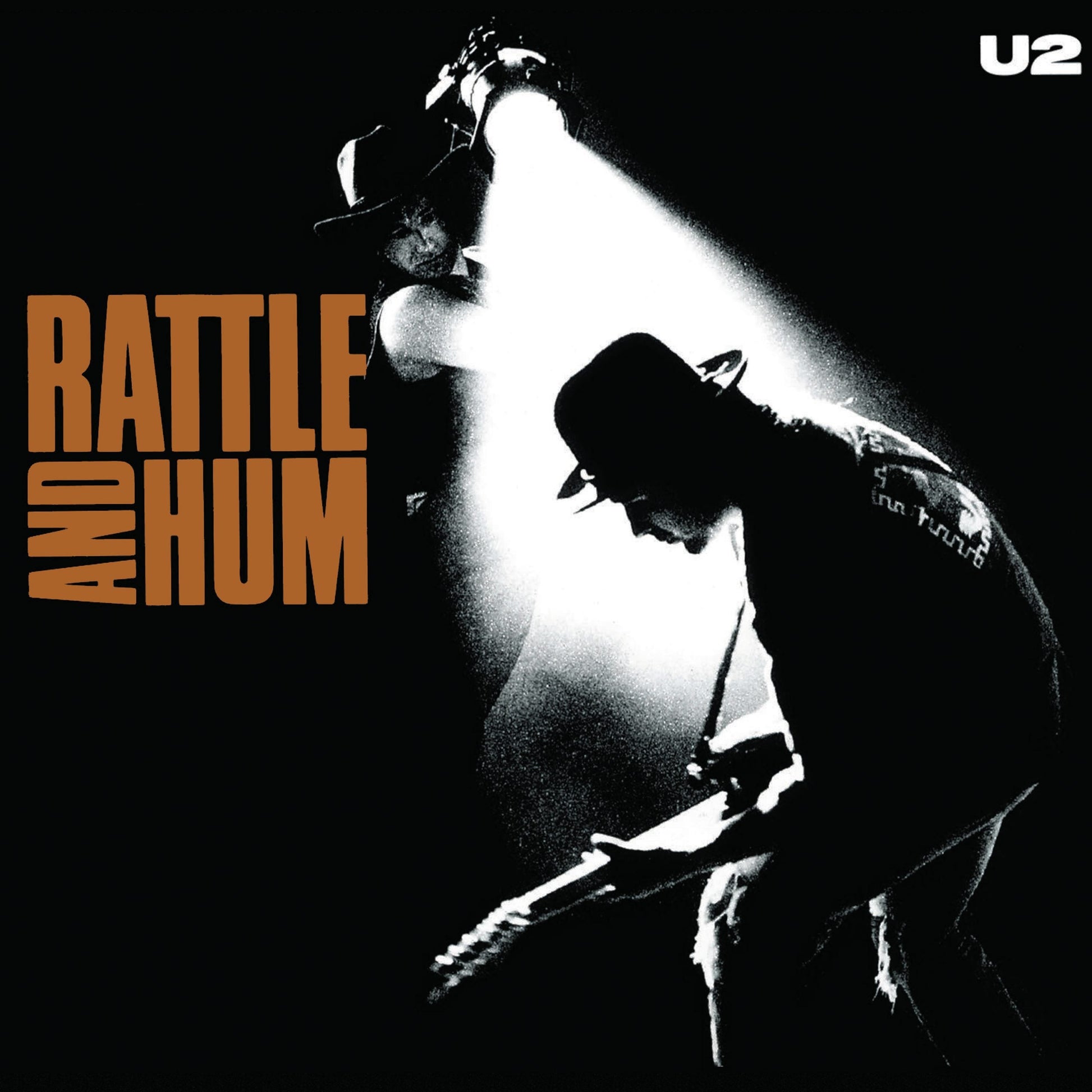 U2 Rattle and Hum vinyl album cover, orange title text with black-and-white band photo