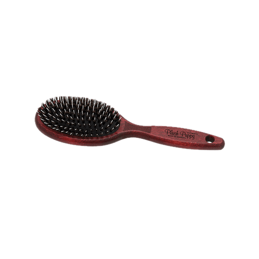 Porcupine hair brush with oval black bristle head and reddish-brown ergonomic handle