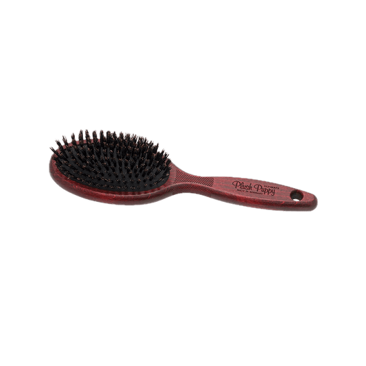 Boar bristle hair brush with round red paddle base and ergonomic brown handle