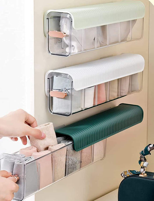 Two wall-mounted storage organizers with clear compartments, white rails, and one green rail