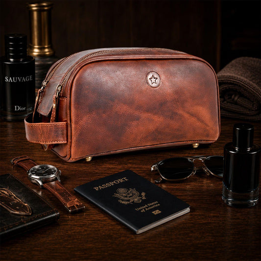 Brown leather dopp kit with top zipper, leather side handle, and embossed emblem.