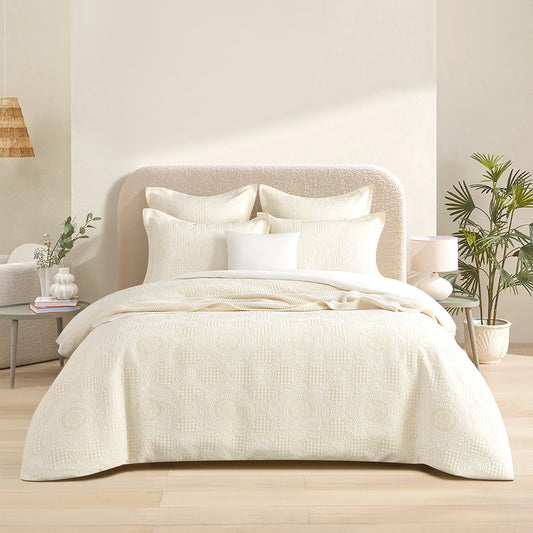 Beige jacquard queen quilt cover set with subtle circular pattern and matching pillowcases.