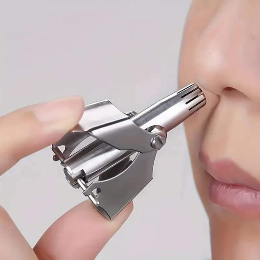 Stainless steel manual nose hair trimmer with hinged guard and clip, held near face