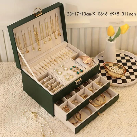 Green jewelry storage box with open lid, necklace bars, ring and earring compartments