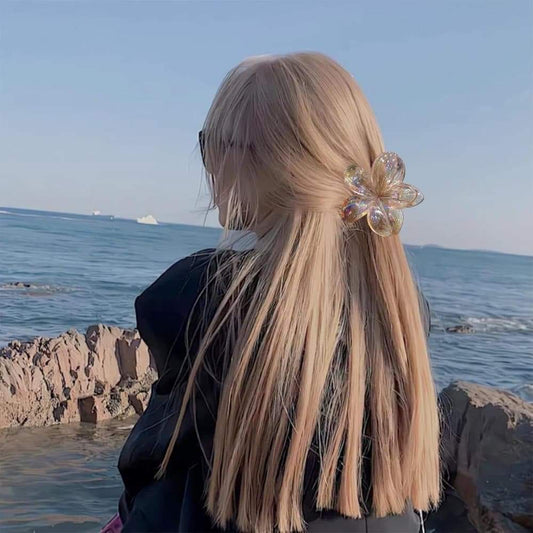 Iridescent flower hair clip on long blonde hair, rainbow shimmer