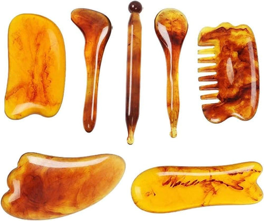 Amber-brown resin gua sha set with curved scrapers and a small comb tool