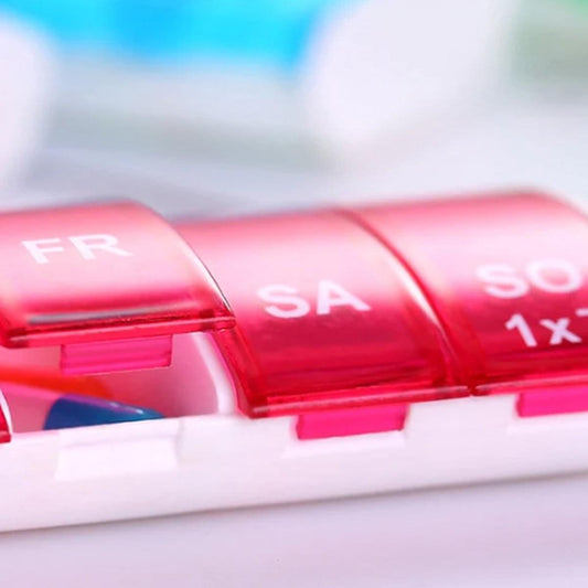 7-day pill organizer with snap compartments, red translucent lid and base.