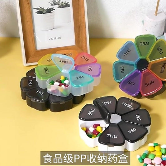 Rotating 7-day pill organizer with day-labeled compartments, multi-color