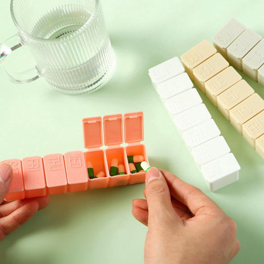 Orange 7-day pill box with daily dividers, lid open