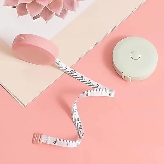 Round measuring tape with white flexible tape and mint-green case, held for measuring