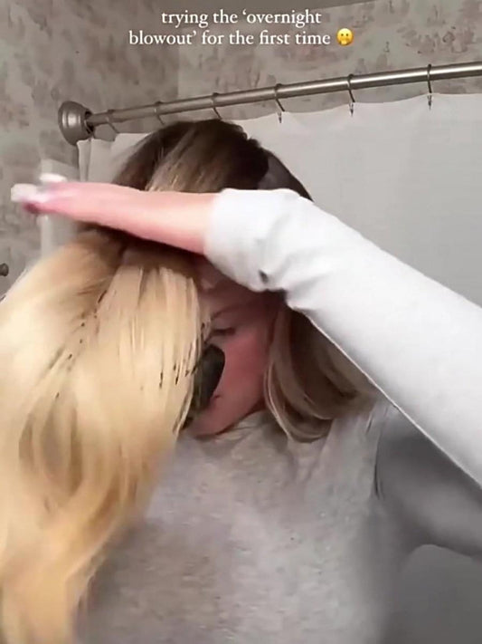 Satin heatless hair curler wrapped over long hair with a hand motion