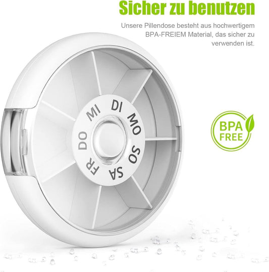Round white pill box with lid open, revealing divided day compartments and center dial.