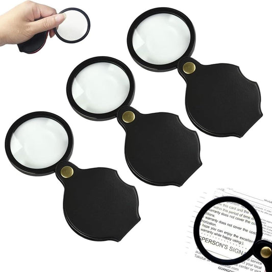 Set of three pocket magnifying glasses, black frames, clear lenses, gold buttons