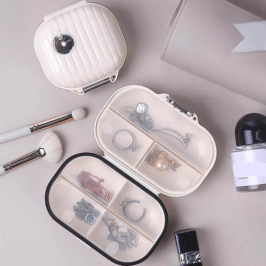 White 7-day pill organizer with hinged halves open showing multiple divided compartments.