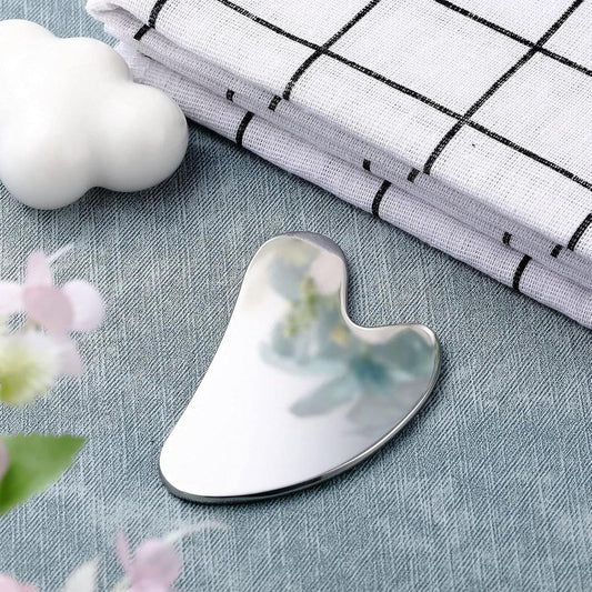 Silver curved heart-shaped gua sha scraper with polished reflective surface