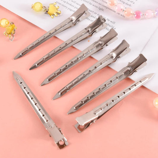 Silver duckbill hairpins with hole rows, metal clips laid out for styling