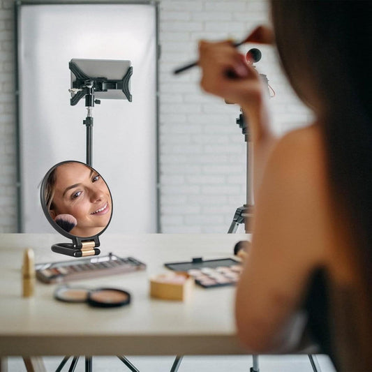 Round magnifying mirror on a desk stand with black folding handle frame