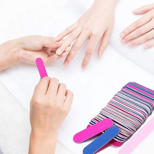 Mini nail sanding strip for manicure, pink and blue, held between fingers