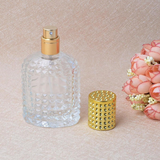 Refillable perfume spray bottle, clear glass with gold cap and textured pattern