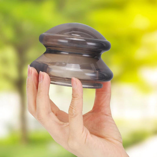 Black silicone cupping cups held in one hand, four sizes