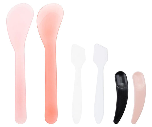 Set of plastic facial cream scoops in pink, peach, white and black spatula tips