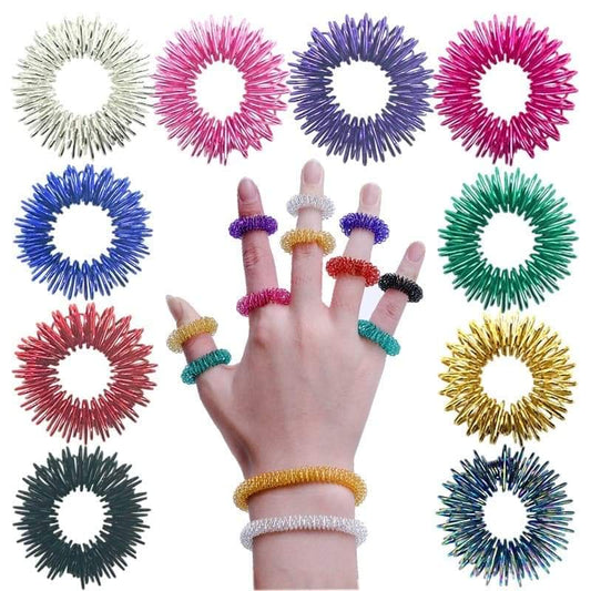 Colorful spiky fidget stress ring set on fingers: white, pink, purple, blue, green