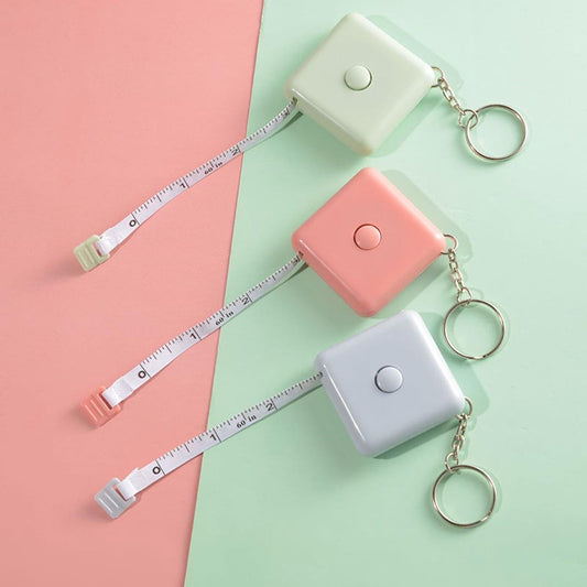 Set of three extendable tape measures with keychain cases in blue, pink, and green.
