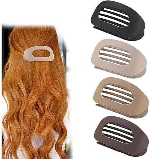 Four flat hair clips with ridged inner teeth in black and tan shades