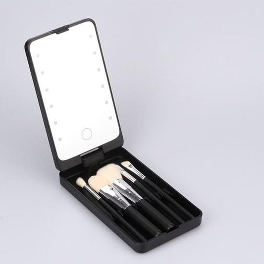 Black makeup brush storage case with hinged LED mirror and five brushes