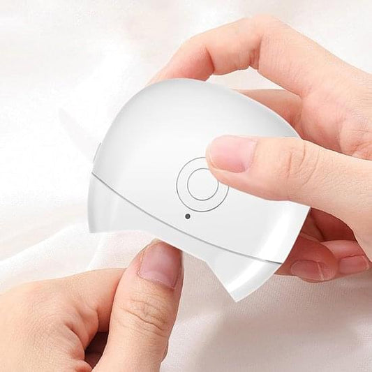 White automatic electric nail clipper held in hands, with circular control button
