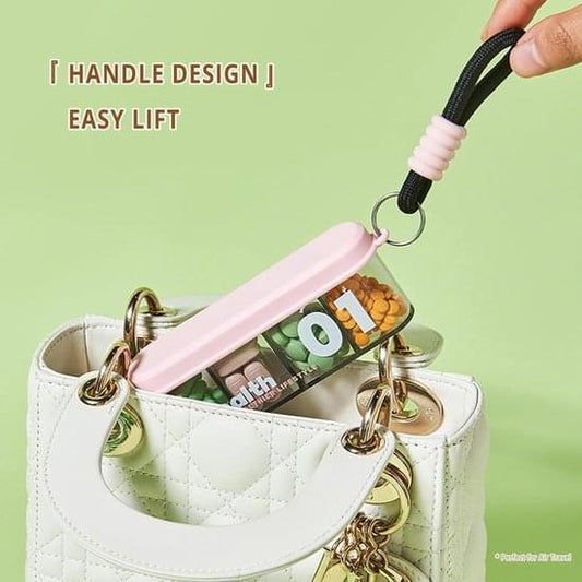 Light pink four-compartment pill box with keychain handle, open clear compartments