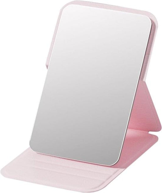 Pink foldable makeup mirror with frameless reflective surface and stand-up base