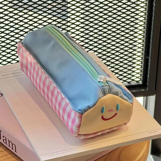 Large pencil case with blue fabric, pink gingham side, and smiling face patch